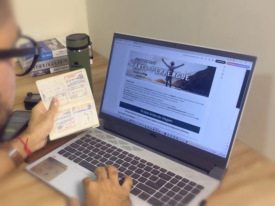 Renison Andrade conferindo o Checklist Anti-Perrengue no notebook com o passaporte na mão
